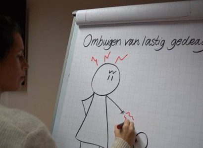 Vrouw schrijft op whitepaper ‘ombuigen van lastig gedrag’ met een gefrustreerd getekend poppetje eronder