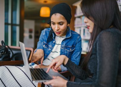 Twee rijksmedewerkers kijken naar een laptop