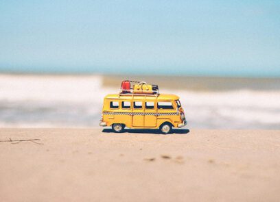 gele speelgoedbusje op het strand